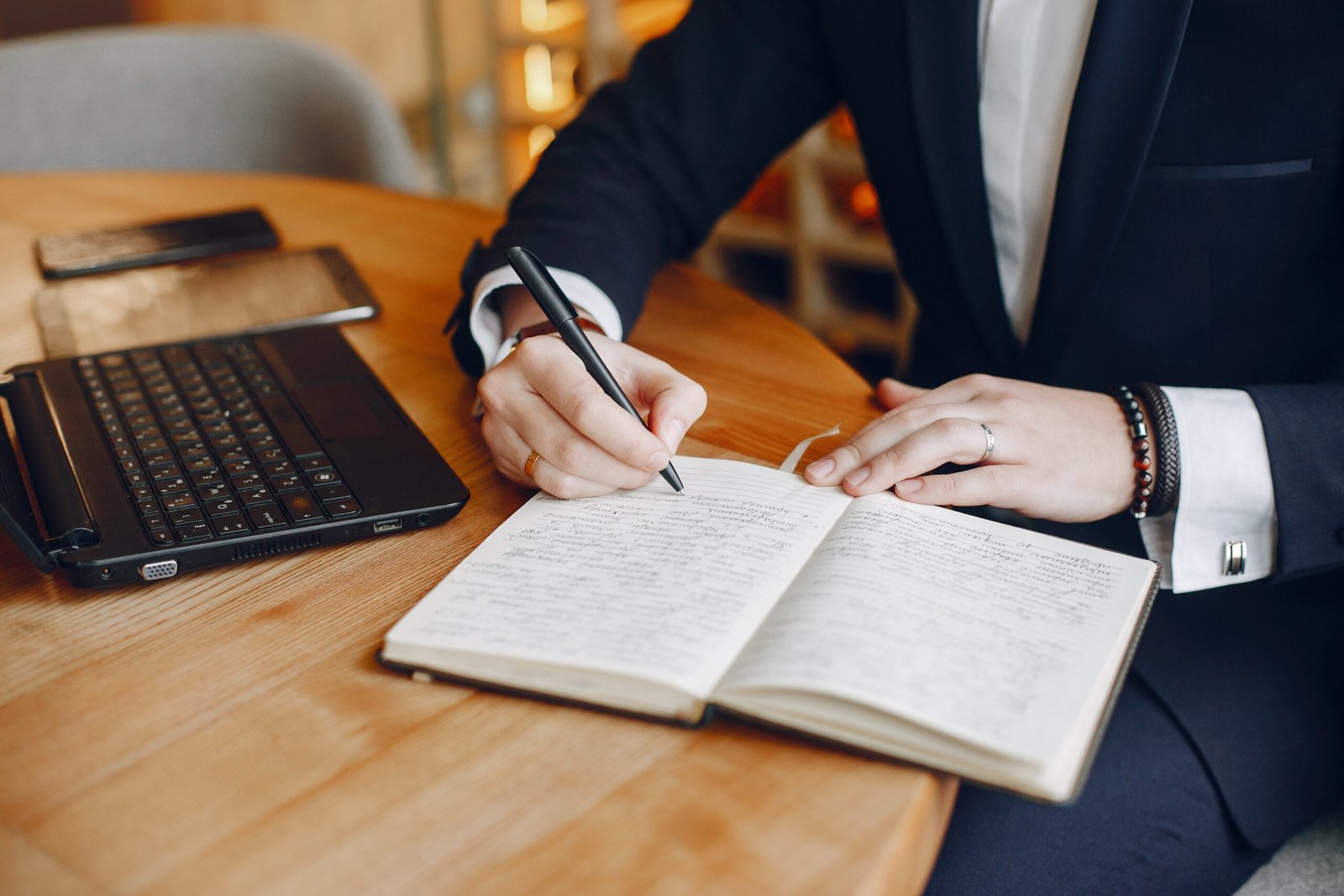 Handsome man in a black suit. Businessman working in a cafe